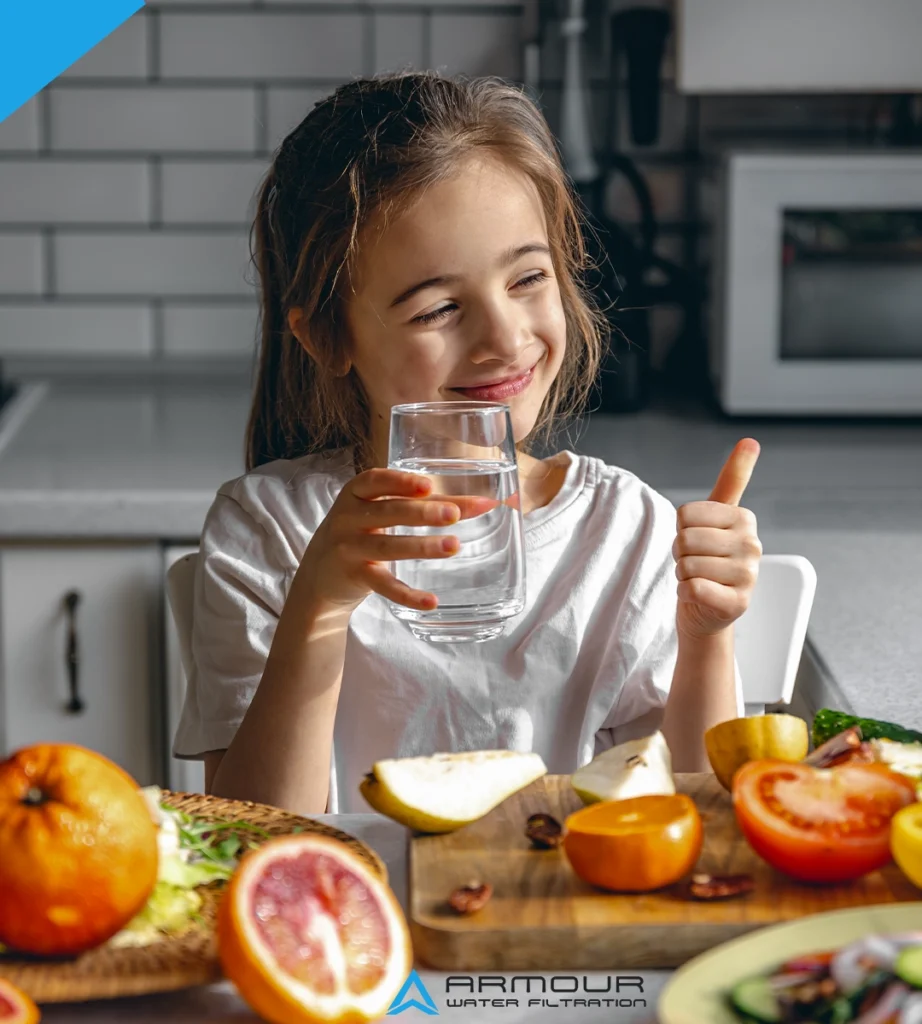 Child drinking clean filtered water at home, reducing PFAS forever chemicals for safer and healthier drinking water.
