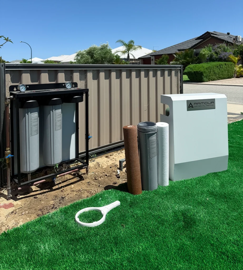 Whole home water filtration system with replacement cartridges displayed beside the unit for maintenance and improved water quality. Water filter systems.