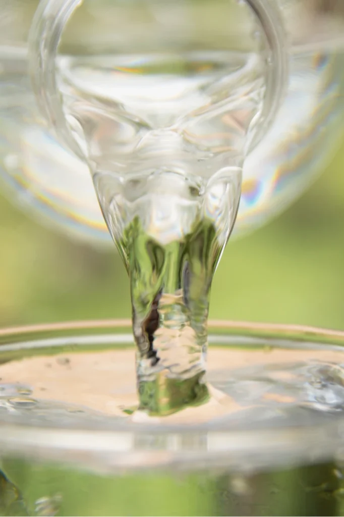 pouring water from a plastic bottle to a glass